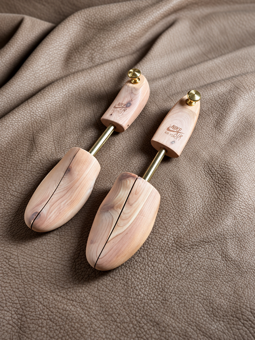 Matched pair of Nike Air Force 1 cedar shoe trees with gold-tone hardware on taupe leather