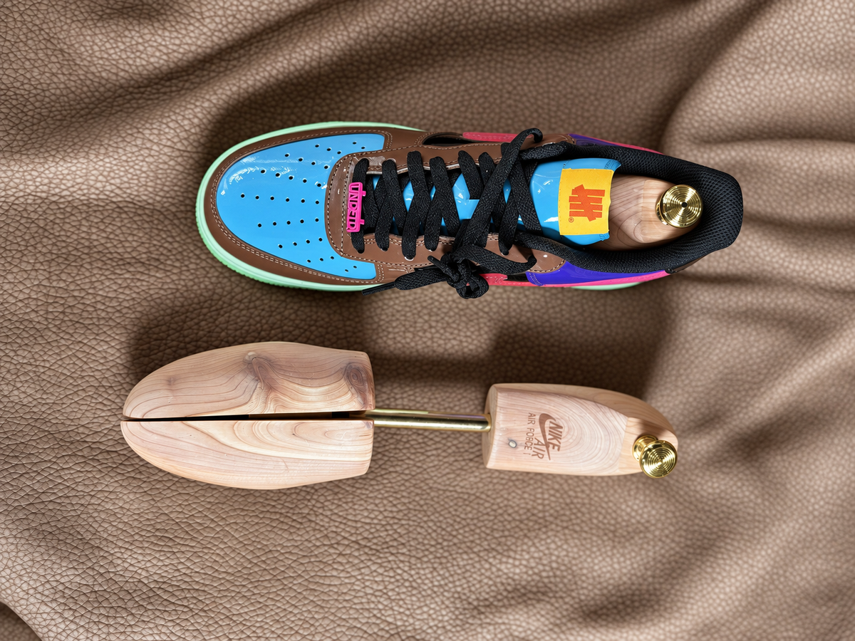 Gold-tone cedar shoe tree seated in an Air Force 1 beside the matching tree; sneaker not included